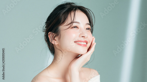 笑顔で綺麗な肌と白い歯を見せる日本人女性美人モデルの美容ポートレート。オーラルケア、スキンケア、コスメ広告用。