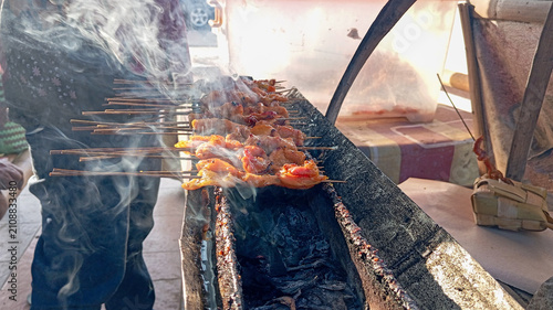 Fotografía Indonesian chicken satay skewers grilled over traditional charcoal street food