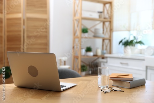 Comfortable workplace with laptop on wooden table indoors