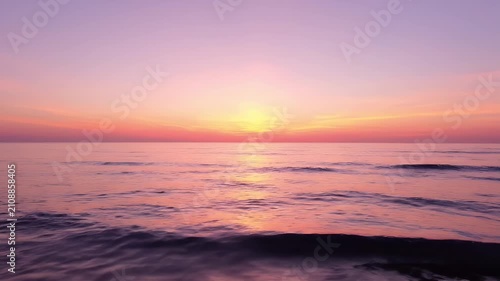 Tranquil Sunset Over a Quiet Ocean with Soft Purple and Orange Hues