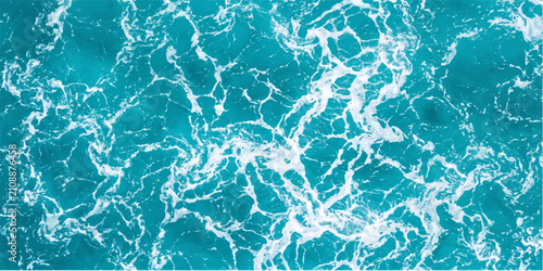 Turquoise ocean waves create an abstract pattern of foam and currents, showcasing the dynamic beauty of the sea from an aerial perspective.