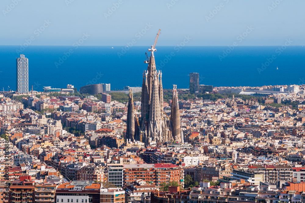 Fototapeta premium Elevated View of Barcelona City With Famous Sagrada Familia Church and Mediterranean Sea in the Horizon