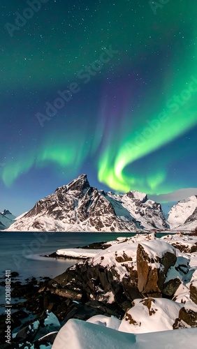 Snowy mountains under vibrant green aurora borealis (1)