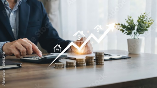 Businessman using a calculator with rising real estate interest rate growth graph