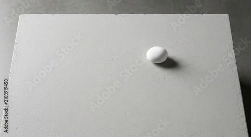 Single white pill on gray surface.