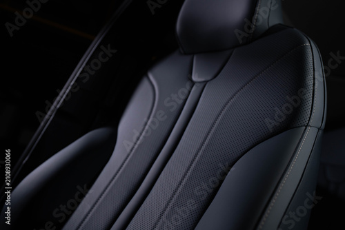Konstfotografi Close‑up of car seat backrest and headrest upholstered in dark perforated leather with visible stitching