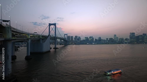大きな橋とビル群が見える東京湾の夕景。