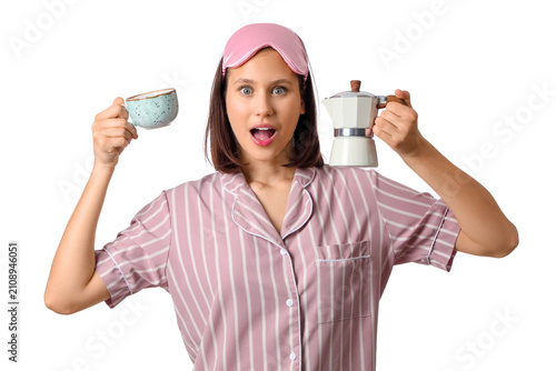 Surprised young woman in pajamas with geyser coffee maker and cup of espresso...
