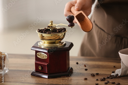 Woman adding coffee beans i...