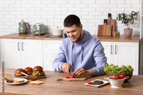 Young man cutting tomatoes ...