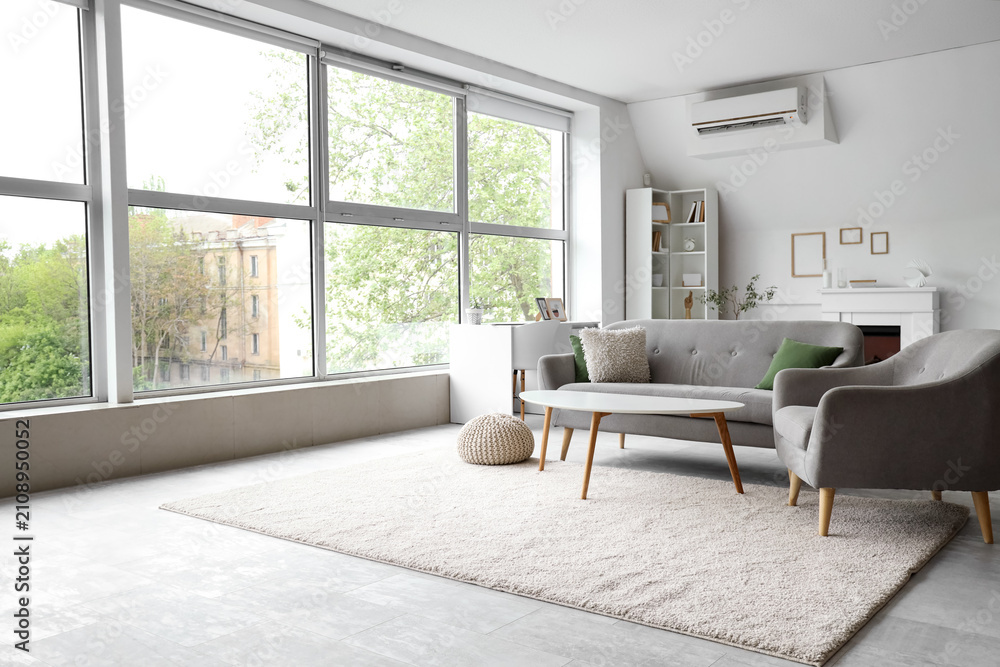 Obraz premium Interior of light living room with grey sofa, armchair and coffee table