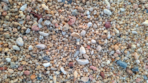 Cuadro en lienzo Detailed top view macro shot of natural beach sand grains with tiny colorful pebbles and coral shell fragments