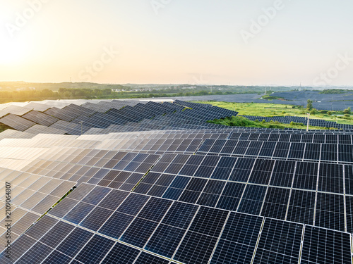 Fotografie A sprawling utility-scale solar photovoltaic farm generates clean renewable energy under the morning sun