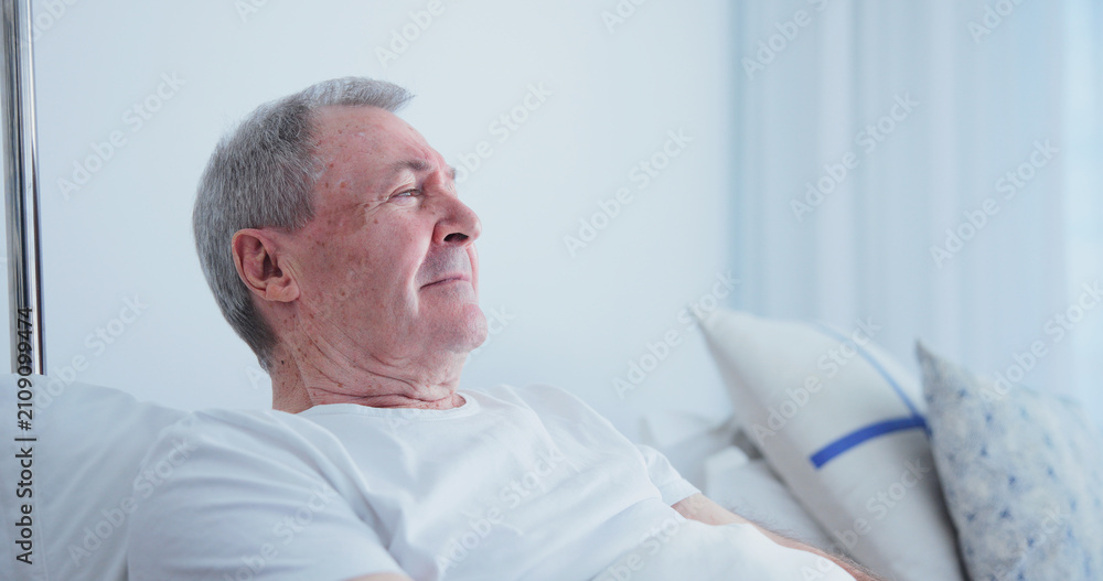 Fototapeta premium Thinking, old man and rest in bed at hospital, medical results and recovery for chronic illness. Sad, senior person and vision at facility for bad news, cancer diagnosis and geriatric rehabilitation
