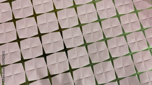 Foto An abstract background featuring a pattern of textured white geometric squares arranged diagonally on a green surface