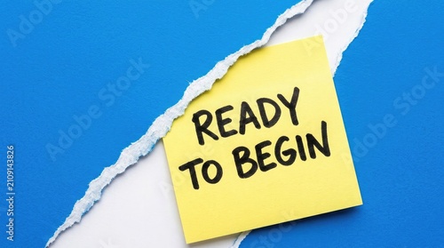Ready to begin message on yellow sticky note with torn paper background