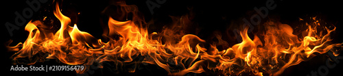 Fotografie Fiery orange and yellow flames licking upwards against pitch black background, wild fire texture with glowing embers and smoke, abstract and dramatic display of intense heat and power