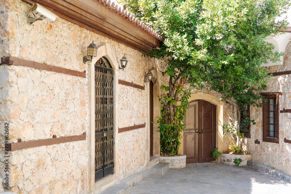 Fototapeta premium Stone Walled Old Town Alley with Arched Wooden Door at Antalya Kaleici