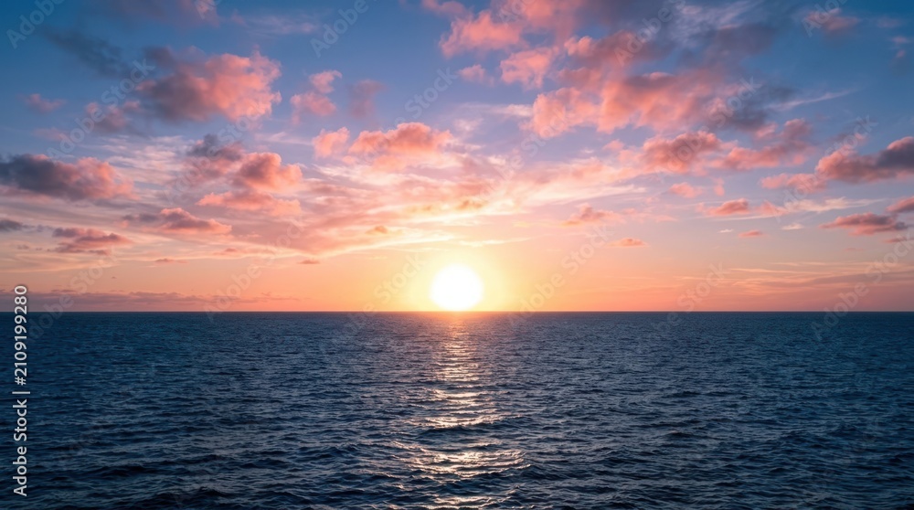 Fototapeta premium Vibrant sunset over the vast ocean with scattered pink clouds and shimmering reflection