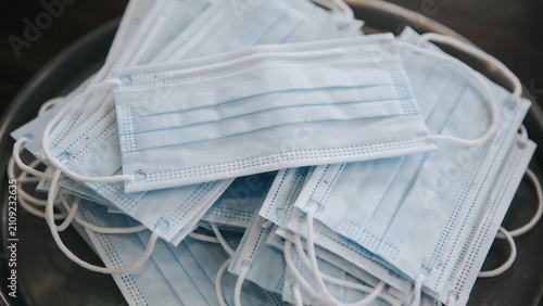 Stack of disposable protective face masks in tray with disposable, protective