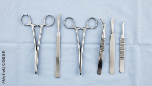 Professional medical and surgical steel instruments on a blue cloth background