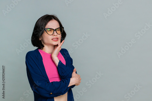 Принти на полотні Young woman touches her cheek, grimacing visibly from intense pain clearly indicating toothache or dental discomfort