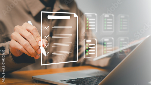 approval,efficiency,signature,policy,Business professional reviewing digital checklist documents on a laptop with electronic approval, compliance verification and document management workflow.