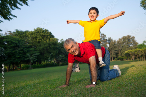 Portrait of grandfather giving grandson a piggyback ride