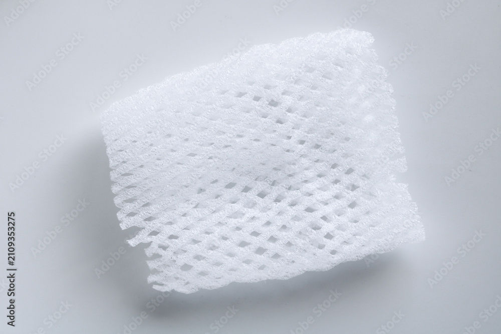 Fototapeta premium Detailed shot of a flexible white mesh foam sleeve used for packaging and protecting delicate fruit.