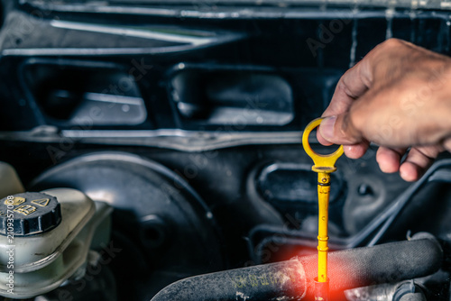 Hand asian worker mechanic in car station oil change ,check engine and measure level oil to change oil car repairman to fix car to check dangers caused by car before traveling to travel with family