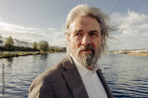 Portrait of serious senior man at a lake