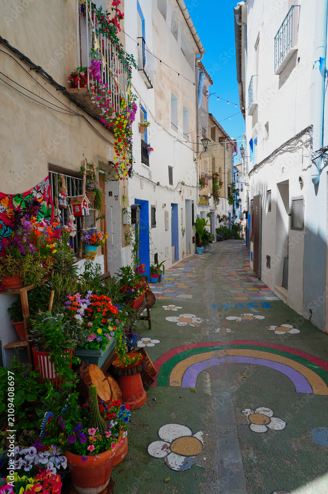 Fototapeta premium Charming traditional street in Chelva, Valencia, Spain, featuring colorful facades, flower pots, and authentic Mediterranean architecture. A picturesque destination reflecting local heritage