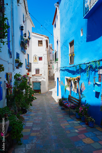 Charming traditional street in Chelva, Valencia, Spain, featuring colorful facades, flower pots, and authentic Mediterranean architecture. A picturesque destination reflecting local heritage