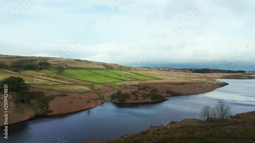 Yorkshire Moorlands in the English countryside. Bleak barren moors or pennines. Calm lake with heather covered hills.