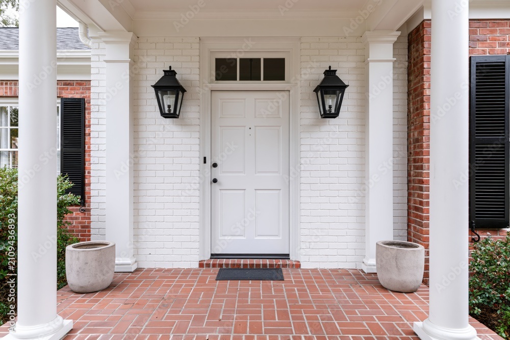 Fototapeta premium The White Brick Front Porch Entrance with Lantern Lights and Red Tile Floor