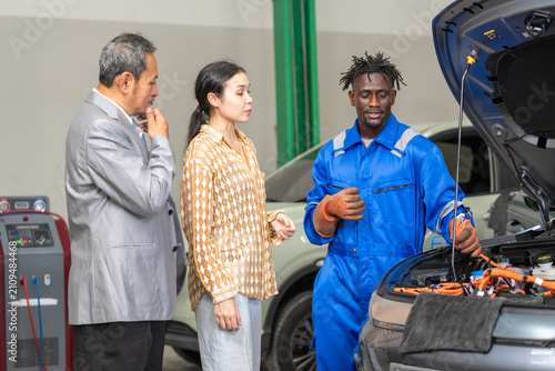 Obraz na plátně Automotive expert shares essential car maintenance tips with eager customers in