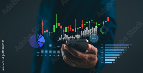 A person holding a phone with overlaid financial charts, graphs, and data visualizations representing market trends and analytics.