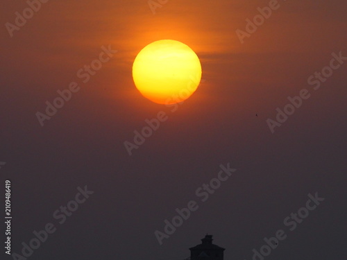 Obraz na płótnie un gran sol de color amarillo bajo el cielo naranja nos da un bonito amanecer un