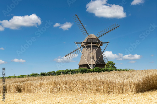 A partially harvested grain field with an old grain mill in the background – 9380