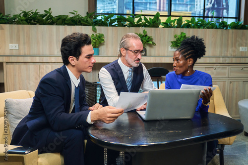 Diverse Business Team Analyzing Data and Strategic Planning in Modern Coworking Space