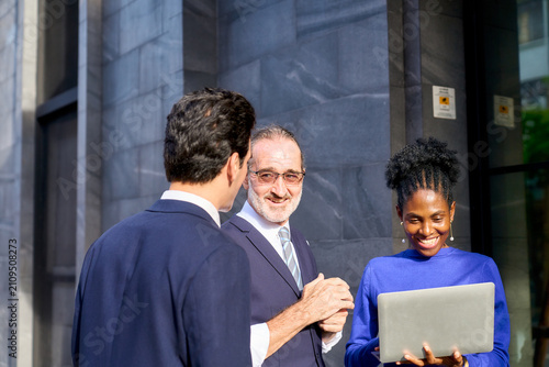 Diverse Professional Team Collaborating with Laptop Near Modern Office