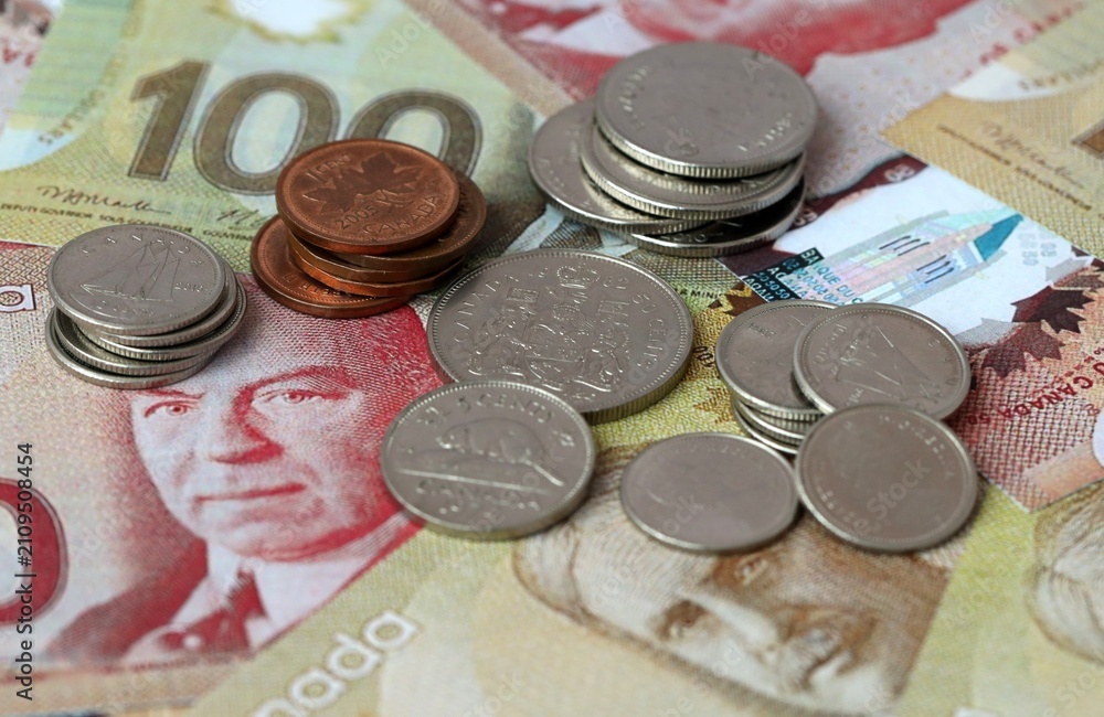 Fototapeta premium Canadian dollar money banknotes and coins on table. Canada cash bills of CAD currency