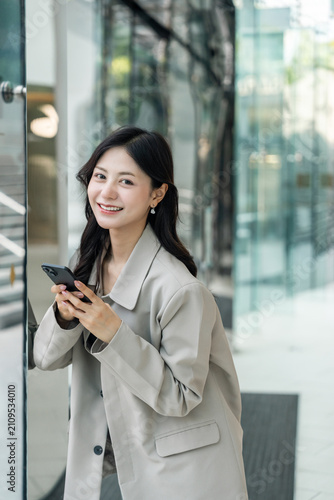 Beautiful business woman using mobile phone work in business buildings. Smart female using cell phone chatting for business communication talking. Business lifestyle concept.