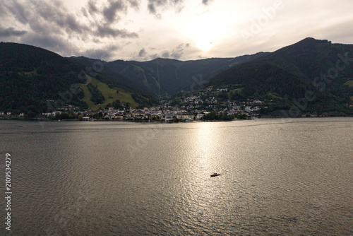 Zell am See, Austria - June 08 2026: Drone flying over the lake, following a boat, beautiful sunset and weather. Spring time in the alps.