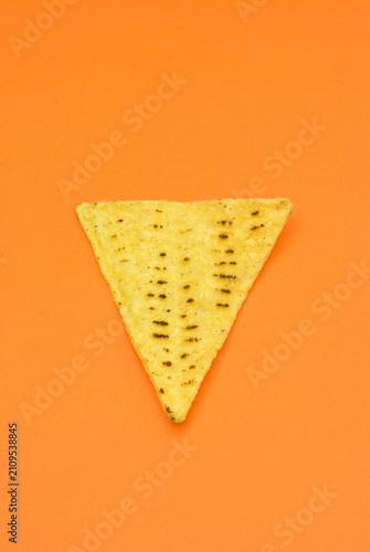 Tortilla chips in closeup on orange table

