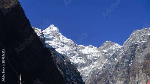 Neelkanth Parvat, Himalayas, snow-covered peak under clear blue sky with sunlight shining brightly on the mountain range