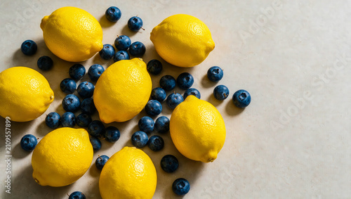 Vibrant yellow lemons encircle rich deep blue berries, creating a striking contrast and a fresh, colorful still life arrangement.