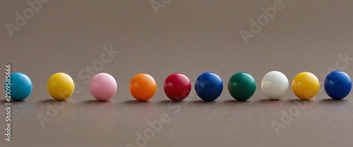 Colorful round beads arranged in a straight line on a neutral surface