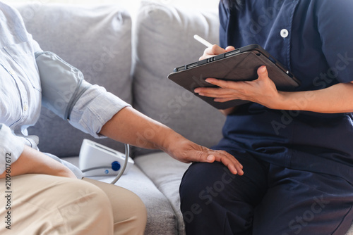 Foto Nurse measuring senior patient pulse during medical check session