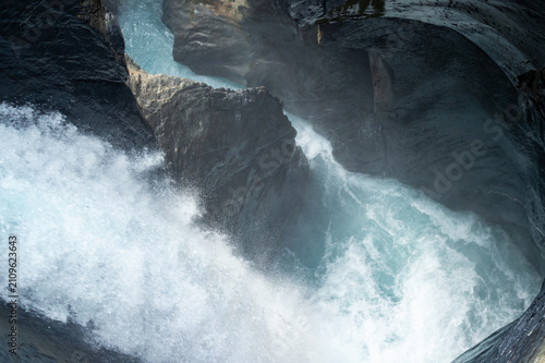 Canvas Print A high-angle view captures a powerful waterfall rushing through a narrow rocky gorge
